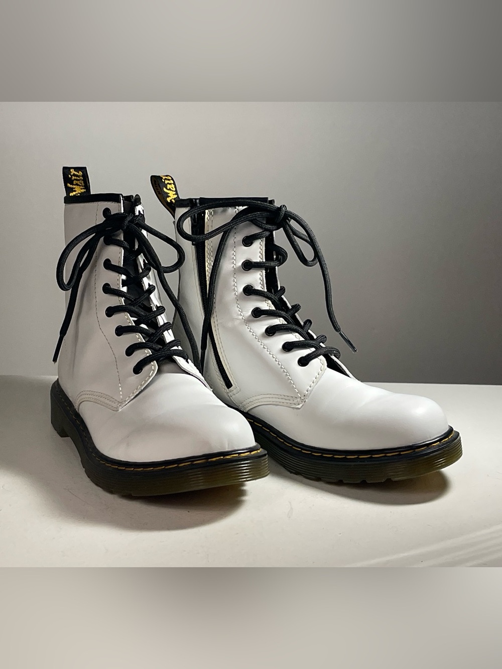 Dr. Martens white 8-eye lace up combat boots. Fits men size 6 and women size 7.